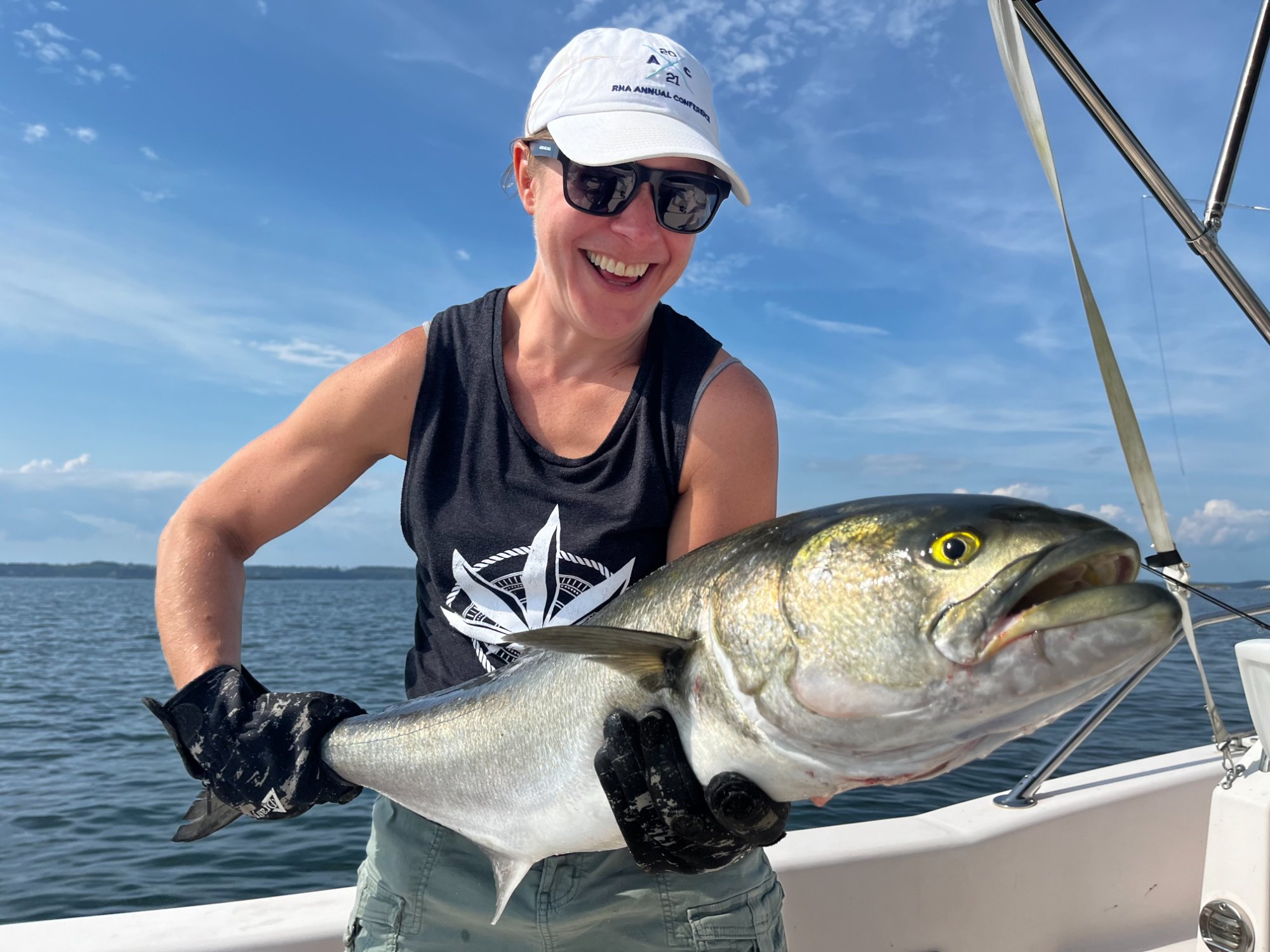 Happy angler with a bluefish on a sunny day