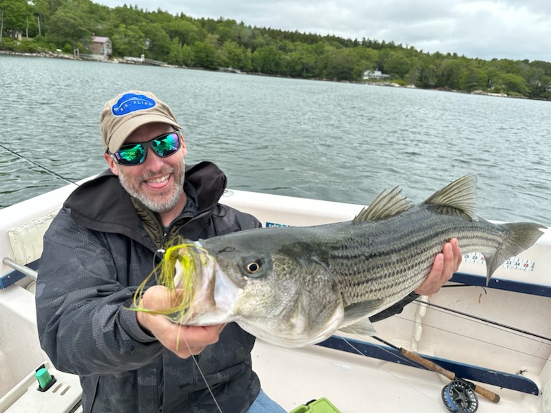 Happy angler with a large striped bass on F/V Bad Cast